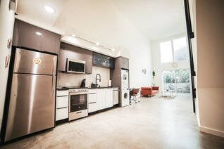 Photo of an open kitchen with stainless steel refrigerator and appliances